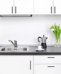 Modern kitchen with black and champagne bronze knurled cabinet handles installed on white cabinets and drawers