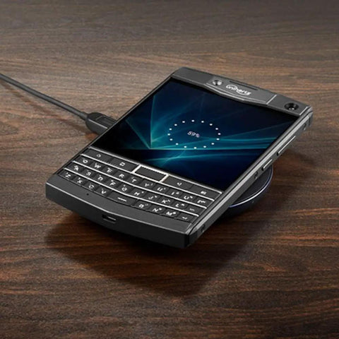 Tough As Nails Rugged QWERTY Smartphone Powered By Rock Solid Android 10 Platform resting on a wireless charger on a wooden surface.