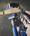 Close-up of a Dremel rotary tool with 1/2-inch coarse sander bands (6-pack) installed, sanding a wooden workpiece.