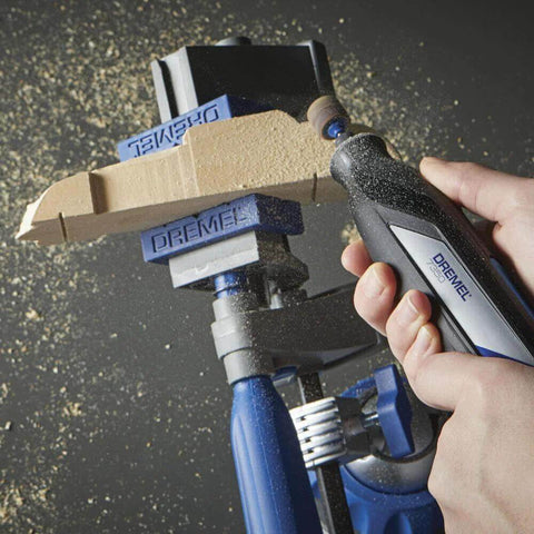 Close-up of a Dremel rotary tool with 1/2-inch coarse sander bands (6-pack) installed, sanding a wooden workpiece.