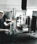 Technician operating industrial equipment in a sleek modern environment.