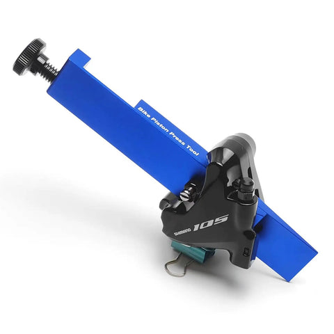 Universal Bike Disc Brake Piston Press Tool For Shimano And SRAM Calipers Piston Spreader And Compressor 24mm Wide 0.95 Inch Fast Piston Press For Easy Caliper Service And Maintenance in blue aluminum with caliper attached