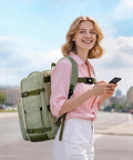 Woman wearing the Layover-Ready Underseat Travel Backpack For Airlines With 2 Packing Cubes, Dirt-Resistant 35L Personal Item Bag, TSA Approved Carry-On Underseat Bag For Women, Fits Frontier, Spirit, United And More, Green, walking outdoors.