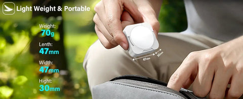 Person holding Rechargeable Tent Lights 2 Pack Portable LED Camping Lanterns beside a bag, highlighting compact size.