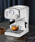 No Drama Stainless Steel Electric Coffee And Milk Frother Machine With Clear Removable Water Tank brewing espresso into a glass.