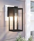 Dusk To Dawn Photocell Sensor Black Outdoor Wall Lantern With Clear Glass Shade on porch wall, bulb lit, sunny day