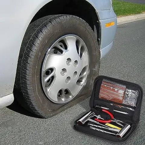 Knuckle Tough Roadside Flat Tire Repair Kit 61 Piece Set with heavy duty steel pliers near a flat tire on a car.