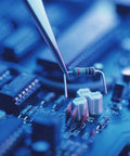 Axial resistor with color bands, close-up view held by tweezers over a blue circuit board