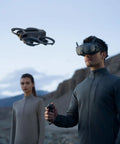 Person flying Avata 2 FPV 4K Drone Dope Fly More Combo With Goggles N3 outdoors in a mountainous landscape.