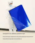 Heavy Duty Tacky Rolls To Knock Grit Off Shoes And Gear Before You Head Into The Cleanroom Or Warehouse Keeps Work Zones Spotless Zero Sweat Guaranteed For Busy Crews with a worker removing a protective layer from a blue mat.