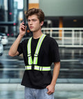 Road Ready Heavy Duty High Vis Safety Strap Vest Engineered For Day Shift Workers Demanding Peak Night Glow And Bulletproof Polymer Straps That Will Never Tear Up In Comfortable Oversized Cut, worn by a young man.