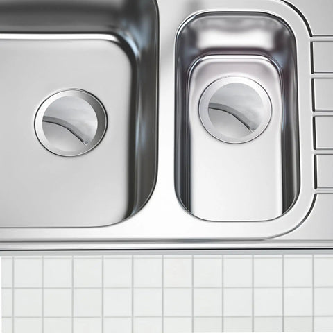 Copper Bathtub Drain Plug with Flat Seal Brass Push Button in a stainless steel sink with round drain holes.