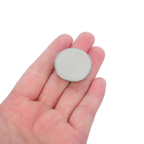 10 Pack Round Stainless Steel Knockout Plugs For Junction Boxes And Electrical Panels displayed in hand for size reference.