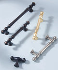 Various kitchen cabinet handles in brushed finishes, including brass, black, and chrome, displayed on a light surface.