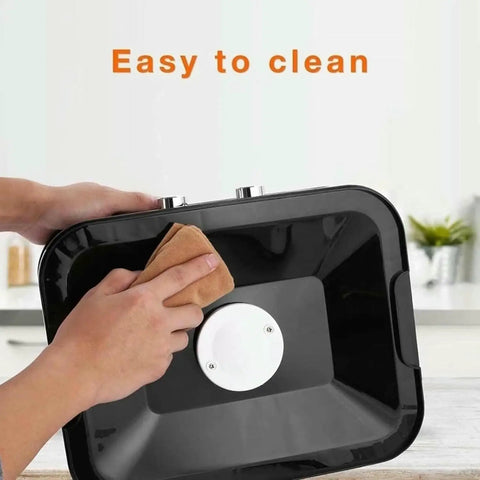User cleaning the black interior of the Hassle Free Countertop Electric Food Dehydrator With Five Generous Removable Trays.