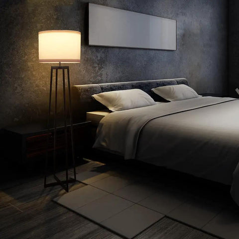 Tall 62 Inch Floor Lamp With Black Metal Base, White Fabric Drum Shade And 9W LED Bulb in a modern bedroom setting