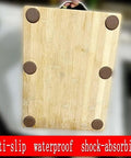 Anti Slip Cutting Board Stabilizer Pads With Self Adhesive Rubber Feet installed on a wooden chopping block.