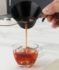 Pouring espresso from Stainless Steel Espresso Shot Cups With Spout And Handle, V Shaped Mouth For Clean Pour, into glass