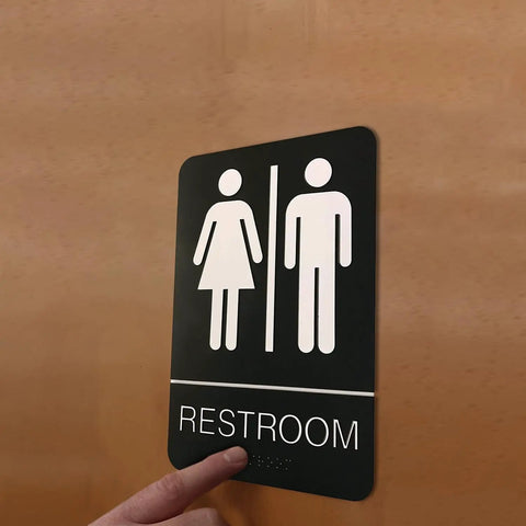 Unisex Braille Restroom Sign With Graphical Symbols And 3M Double Sided Tape For Quick No Fuss Install In Under A Minute 9 By 6 Inches Black Perfect For ADA Compliance Durable Indoor Outdoor Use Easy To Clean.