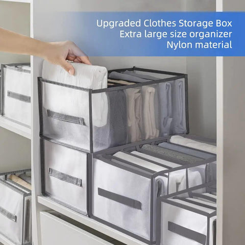 Hand organizing clothes in Six Piece Extra Large Closet Organizer And Storage Set for shirts, jeans, and sweaters on shelf.