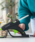 Cordless High Temperature Glue Gun 60W with Standby Base in use for crafting on a table
