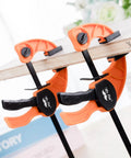 Mr. Pen orange 6-inch bar clamps, 2-pack, woodworking, two clamps gripping a wooden board with black handles