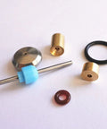 Waterjet on/off valve repair kit parts, front view: brass fittings, steel rod with blue guide, metal disk, and O-rings.
