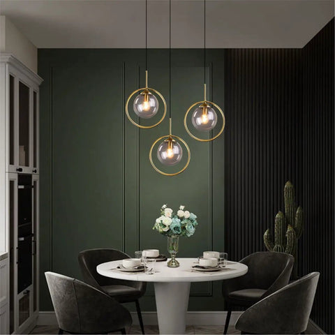 Dope Smoke Gray Glass Globe Pendant Light With Gold Rim hanging above dining table, minimalist style