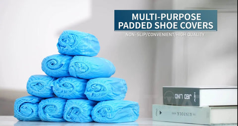 Stack of blue disposable boot and shoe covers 200 pack non slip durable for indoor and outdoor use displayed on a table.