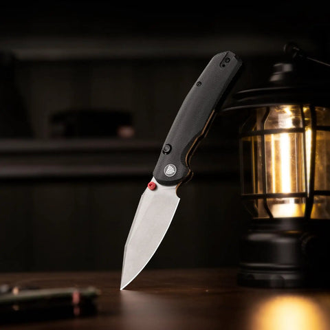 Folding Pocket Knife With A 3.34 Inch Blade And Button Liner Lock, super smooth open, hornet pro upgrade, next to a lantern.