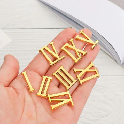 Quartz Clock Numerals Replacement Set Not Self Adhesive For Clock Repair And DIY Wall Clocks Arabic Numbers And Black Roman Numerals Available In Silver Gold Or Black Finish held in hand.