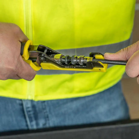 Installer using tool with Universal BNC Compression Coax Connector for RG6 and RG6 quad shield cables in dark nickel