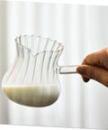 Hand holding Glass Creamer Pitcher With Spout For Turkish Coffee And Espresso, Vintage Milk Jug For Home Barista Vibes