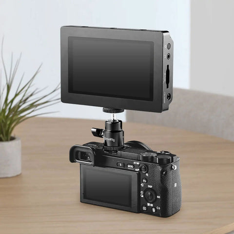 Camera with monitor attached using 1/4 Inch Camera Hot Shoe Mount With Ball Head And Extra 1/4 Inch Screw, on a table.