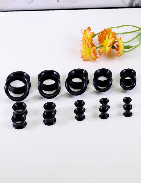 Ultra Thin Silicone Ear Gauge Stretching Kit 4mm to 20mm Black Soft Flexible Tunnels Plugs displayed with orange flowers