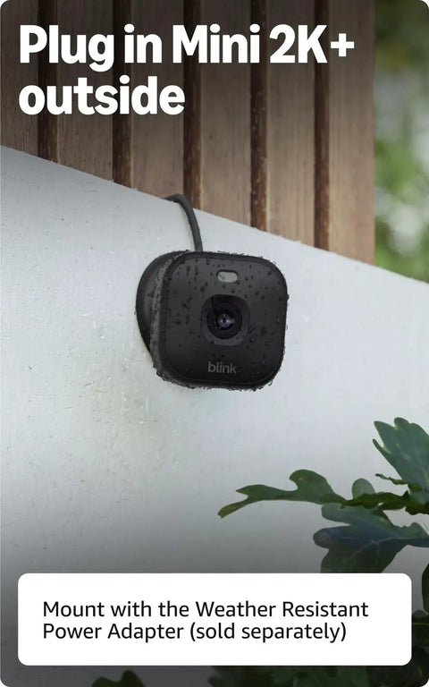 Hella Crisp Two Pack Indoor Security Cameras Running Smooth With 2K Video Resolution Compact Plug In Build Night Vision And Knockout Motion Detection Reliable Home And Pet Monitoring Black mounted outside, showcasing sleek black design with raindrops.