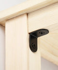 Black Stainless Steel Right Angle Corner Brackets Set With Screws installed on light wood, furniture fastener detail view.
