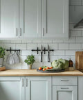Modern kitchen with 4 Inch Matte Black Cabinet Pulls Pack Of 2 Heavy Duty Solid Hardware on gray cabinets and wooden countertop.