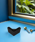 Four Pack L Shaped Sofa Legs With M5 Screws, Thickened Plastic Feet For Furniture, Floor Protection And Easy Cleaning, Dust Reduction For Tables And Dressers, Black Finish shown on window ledge