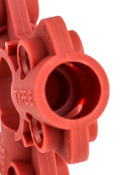 Close-up of red nylon pneumatic quick-disconnect lockout kit, compatible with 1/4 to 1/2 inch connectors for industrial safety.