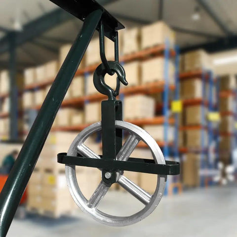 12 Inch Aluminum Scaffold Hoist Pulley With Dual Sealed Bearings, 1000 Lb Working Load, shown with hook in warehouse setting