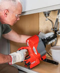 Man using Heavy Duty Cordless Drain Snake With Brushless Motor and Twenty Five Foot Steel Cable for clogs under sink.