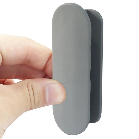 2 Pack Self Adhesive Pull Handles Gray For Cabinets Drawers And Doors Tool Free Installation No Drill Required Easy Sticky Mount Durable Grab Handles For Quick Access And Easy Pull In Any Room. Gray self-adhesive pull handle shown in hand, vertical view for cabinet or drawer use.