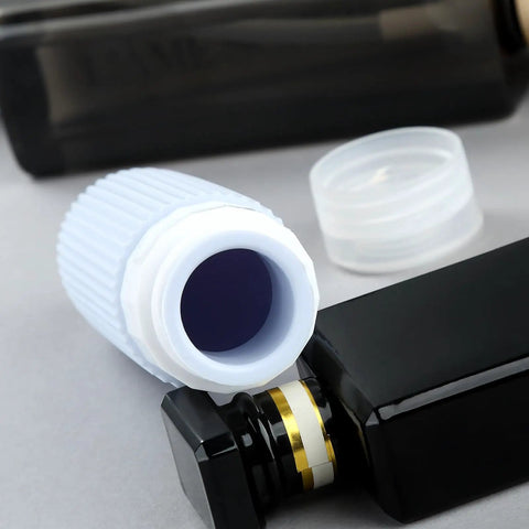 Close-up of TSA Approved Travel Bottle Set With Leak Proof Silicone Squeezable Containers, open lid and black bottle
