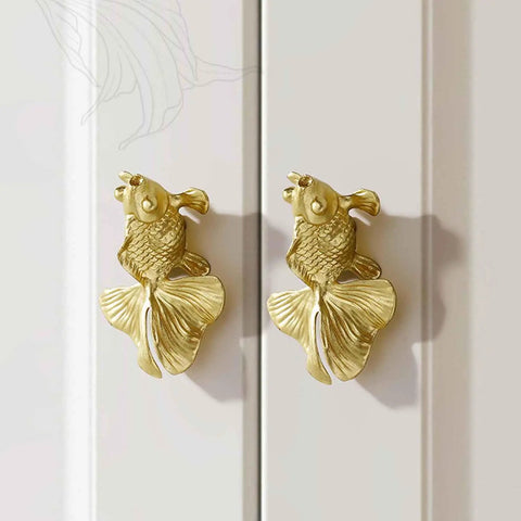 Solid Brass Goldfish Drawer Knobs Set For Cabinets And Dressers, two goldfish-shaped knobs on white cabinet doors