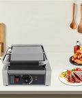 Heavy Duty 1800W Commercial Sandwich Panini Press Grill on countertop with cooked food and adjustable temperature control knob.