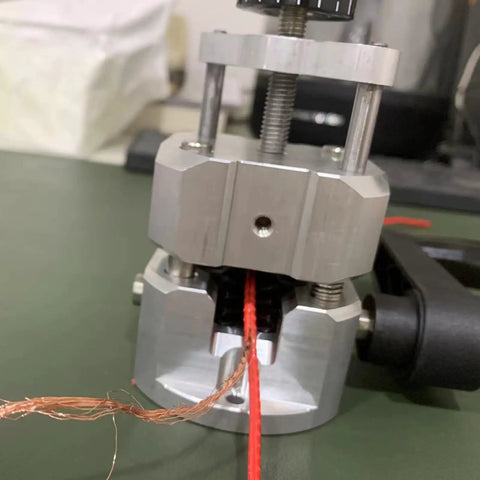 Manual Wire Stripping Tool With Hand Crank, shown stripping red copper wire, durable ABS and PC build, for copper recycling projects