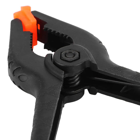 Top Tier 10 Piece Spring Clamps For Woodworking And DIY Projects With Ergonomic Handles That Grip Hard To Hold Boards Securely While You Paint Build Crafts Or Work In Your Studio Without Any Slip Ups On This Ultimate Hand Tool Kit, black plastic spring clamp close-up