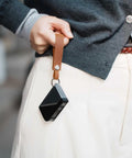 Top Shelf Crazy Horse Leather EDC Keychain Strap With Aerospace Titanium Key Ring For Car Keys held in hand with a black device.