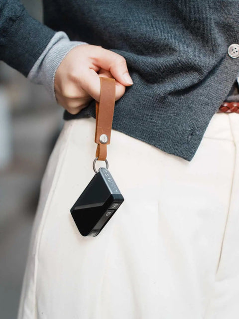 Top Shelf Crazy Horse Leather EDC Keychain Strap With Aerospace Titanium Key Ring For Car Keys held in hand with a black device.
